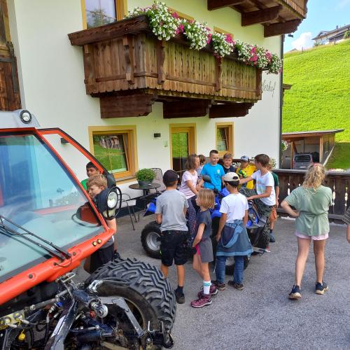 Kinder stehen vor einem Bauernhof